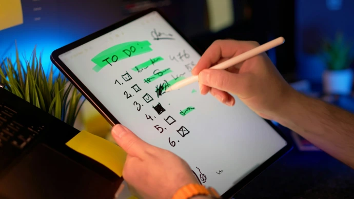 Person using stylus on tablet to check off to-do list