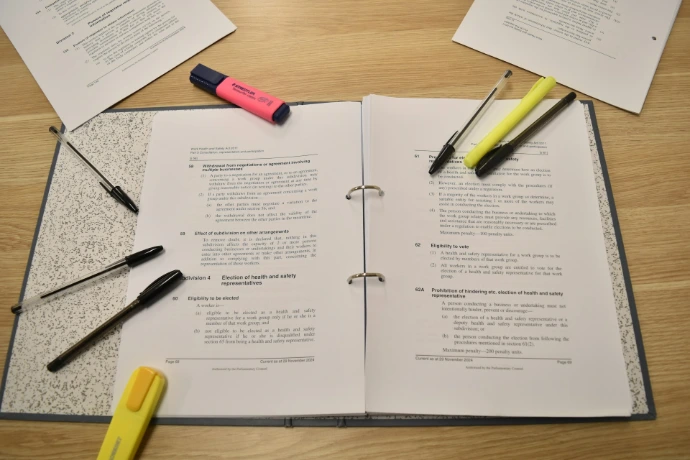 Papers, pens, and highlighters are laid out for studying